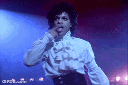 A Man In A White Shirt With Ruffles On The Sleeves Is Licking His Lips GIF