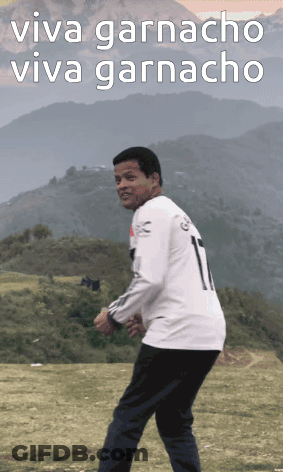 A Man In A White Shirt With The Number 1 On It Stands In A Field GIF