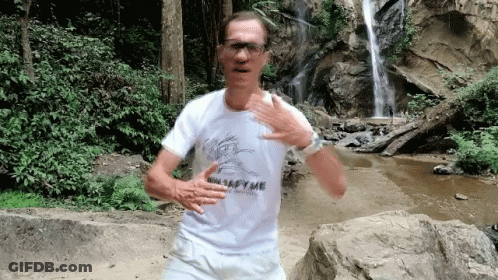 A Man In A White Shirt With The Word Metafyme On It Is Running In Front Of A Waterfall GIF