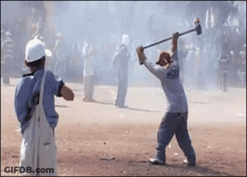 A Man In A White Shirt With The Word Police On The Back Is Holding A Hammer GIF