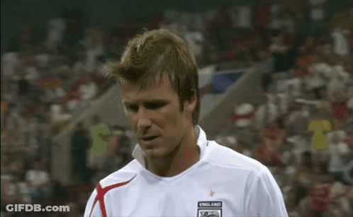 A Man In A White Soccer Jersey Is Standing On A Soccer Field In Front Of A Crowd . GIF