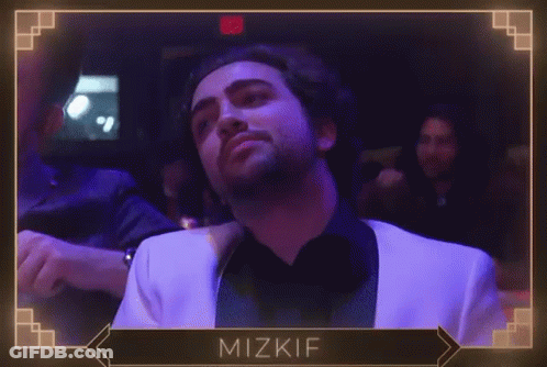 A Man In A White Suit Is Dancing In A Dark Room With The Name Mizkif On The Bottom Right GIF