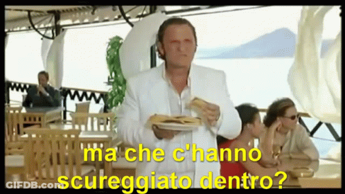 A Man In A White Suit Is Holding A Plate Of Food With The Words Ma Che C'hanno Scureggiato Dentro GIF