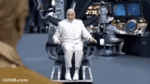 A Man In A White Suit Is Sitting In A Chair . GIF