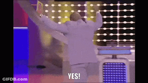 A Man In A White Suit Is Standing In Front Of A Wall With His Arms Outstretched And Says Yes . GIF