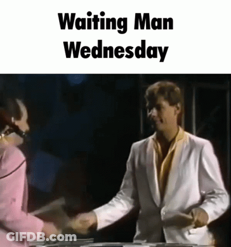 A Man In A White Suit Shakes Hands With A Woman In A Pink Shirt While Waiting For Wednesday . GIF