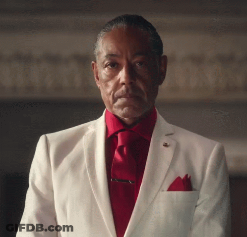 A Man In A White Suit With A Red Shirt And Tie GIF