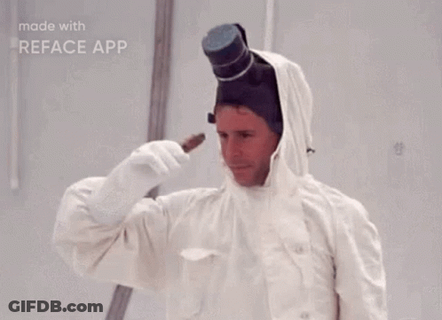A Man In A White Suit With A Top Hat On His Head Is Holding Something In His Hand . GIF