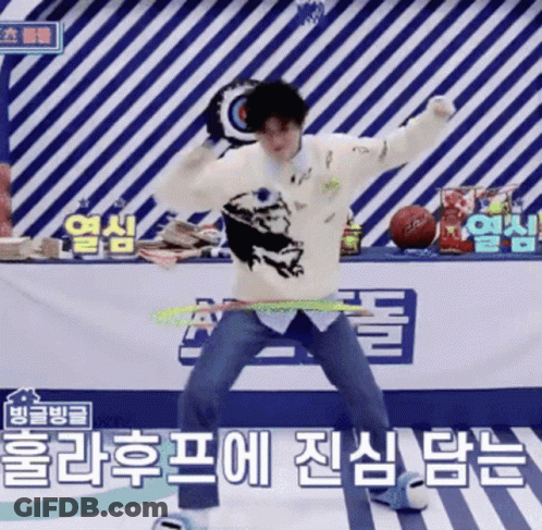 A Man In A White Sweater Is Dancing In Front Of A Sign That Says ' Basketball ' On It GIF