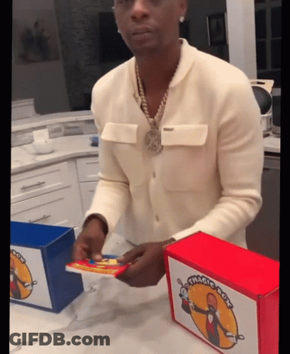 A Man In A White Sweater Is Opening A Box That Has The Word Magic On It GIF