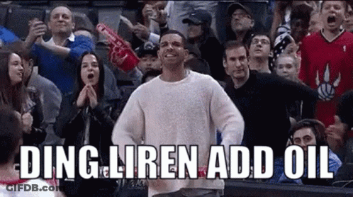 A Man In A White Sweater Is Standing In Front Of A Crowd . GIF