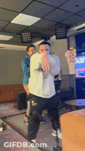 A Man In A White Sweatshirt With The Number 13 On It Is Dancing GIF