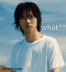 A Man In A White T-Shirt Has The Word What On His Face GIF