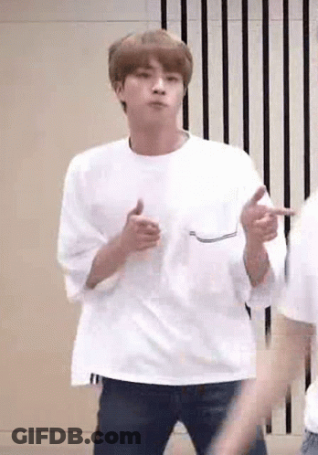 A Man In A White T-Shirt Is Dancing In A Room . GIF