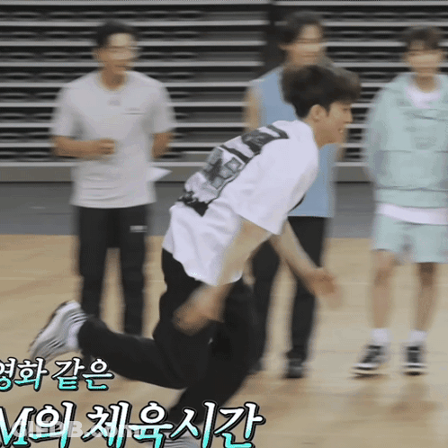 A Man In A White T-Shirt Is Jumping In The Air With Korean Writing On The Bottom GIF