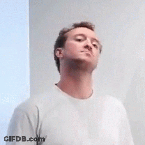 A Man In A White T-Shirt Is Looking Up At Something . GIF