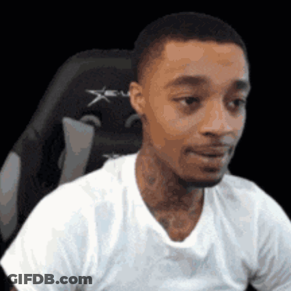 A Man In A White T-Shirt Is Sitting In A Gaming Chair . GIF