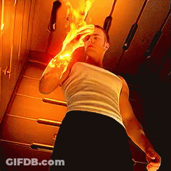A Man In A White Tank Top And Black Shorts Is Holding A Fireball In His Hand . GIF
