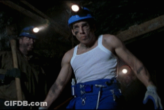 A Man In A White Tank Top And Blue Pants Has A Belt With Tools On It GIF