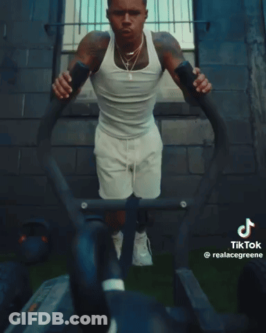 A Man In A White Tank Top And White Shorts Is Doing Push Ups On A Machine That Says Tik Tok GIF
