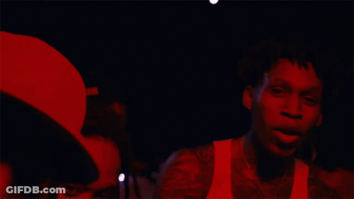 A Man In A White Tank Top Has A Tattoo Of A Horseshoe On His Arm GIF
