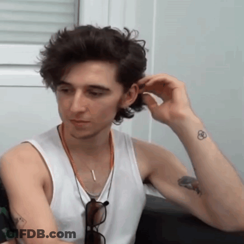 A Man In A White Tank Top Has A Tattoo On His Wrist GIF