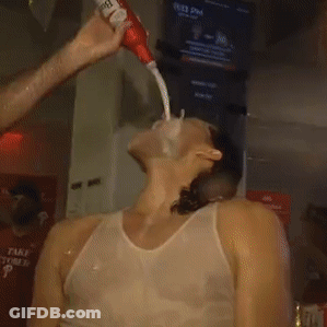 A Man In A White Tank Top Is Being Squirted With A Tube Of Toothpaste GIF