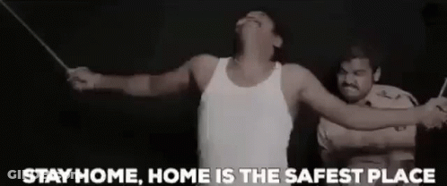 A Man In A White Tank Top Is Being Tortured By A Police Officer With A Stick . GIF