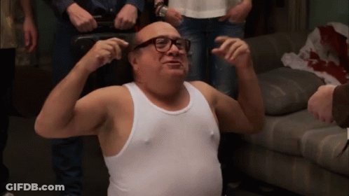 A Man In A White Tank Top Is Flexing His Muscles GIF