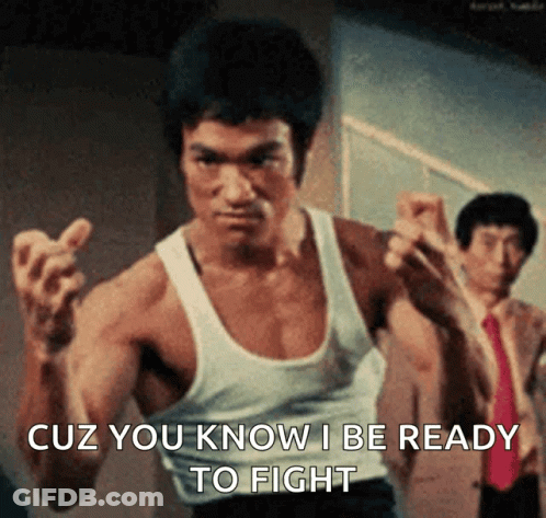 A Man In A White Tank Top Is Ready To Fight . GIF