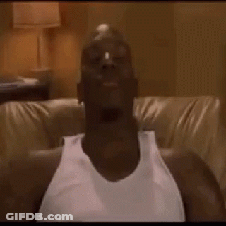 A Man In A White Tank Top Is Sitting On A Couch With His Head In The Air . GIF