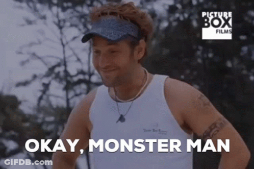 A Man In A White Tank Top Is Smiling And Says " Okay Monster Man " GIF
