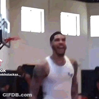 A Man In A White Tank Top Is Smiling In A Gym . GIF