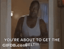 A Man In A White Tank Top Is Standing In A Doorway And Saying `` You 'Re About To Get The Belt !!! '' GIF