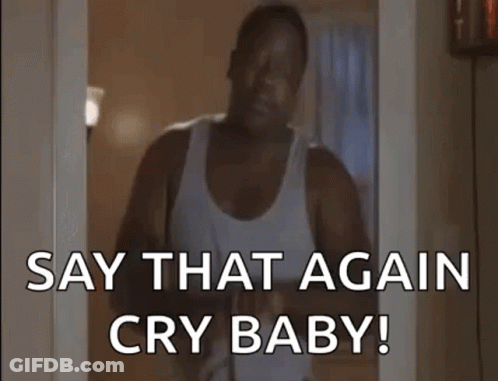 A Man In A White Tank Top Is Standing In A Doorway Holding A Baby And Saying `` Say That Again Cry Baby '' . GIF