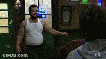 A Man In A White Tank Top Is Standing Next To Another Man In A Fx Hoodie .. GIF
