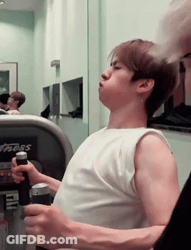 A Man In A White Tank Top Is Using A Treadmill That Says Fitness On It GIF