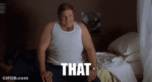 A Man In A White Tank Top Sits On A Bed With The Word That Written Below Him GIF