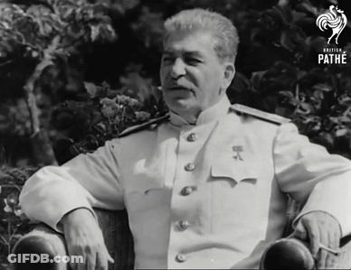 A Man In A White Uniform Sits In A Chair With The Word Pathe On The Bottom Right GIF