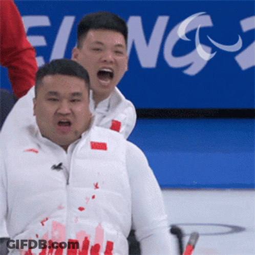 A Man In A White Vest With Chinese Writing On It Is Being Lifted By Another Man GIF