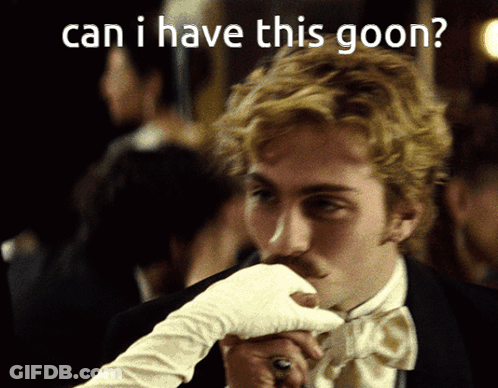 A Man In A Wig And Sunglasses Is Holding A Book GIF