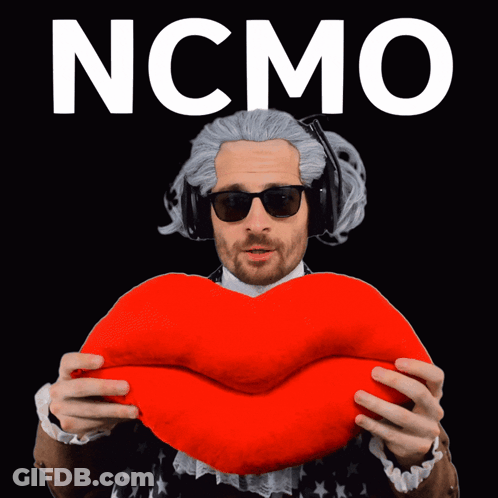 A Man In A Wig And Sunglasses Is Holding A Red Heart With The Word Ncmo On The Bottom GIF