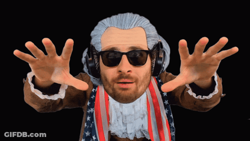 A Man In A Wig And Sunglasses Is Wearing Headphones And An American Flag Jacket GIF