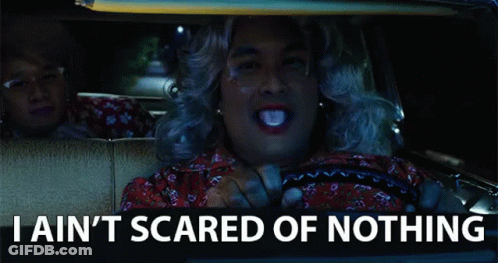 A Man In A Wig Is Driving A Car With The Words " I Ain T Scared Of Nothing " Below Him GIF