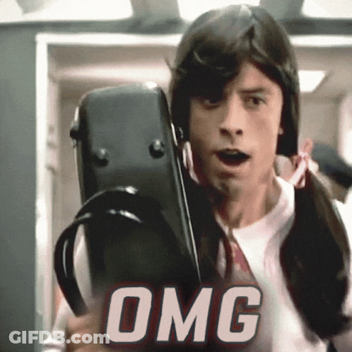 A Man In A Wig Is Holding A Violin Case And The Word OMG Is Behind Him GIF