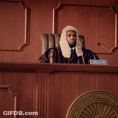 A Man In A Wig Sits At A Desk With The Words Feliz Dia Del Abogado GIF