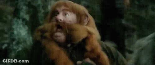 A Man In A Wizard Hat Is Holding A Stick In A Field GIF