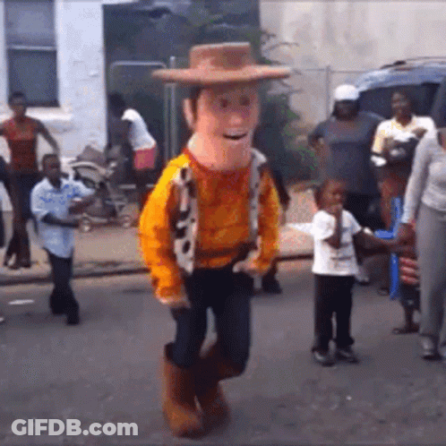 A Man In A Woody Costume Is Dancing On The Street GIF