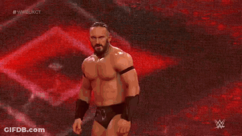 A Man In A Wrestling Outfit Is Walking On A Stage With A Red Background . GIF