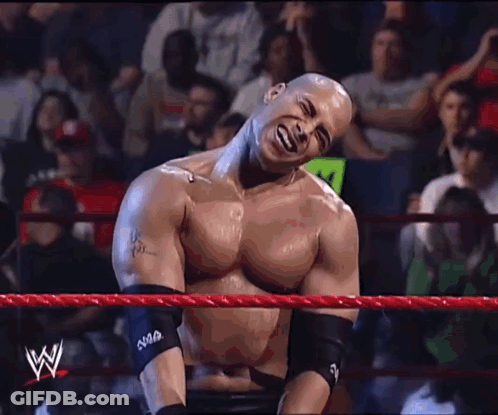 A Man In A Wrestling Ring Has A W On His Arm Band GIF